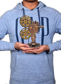 Resin steampunk projector statue held in hands, brass gears and mechanical projector body