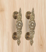 Golden brass door handle pair, round lever plates and engraved leaf patterns
