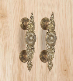 Golden brass door handle pair, round lever plates and engraved leaf patterns
