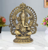 Brass Ganesha idol, seated with ornate halo and raised hands, highly detailed face