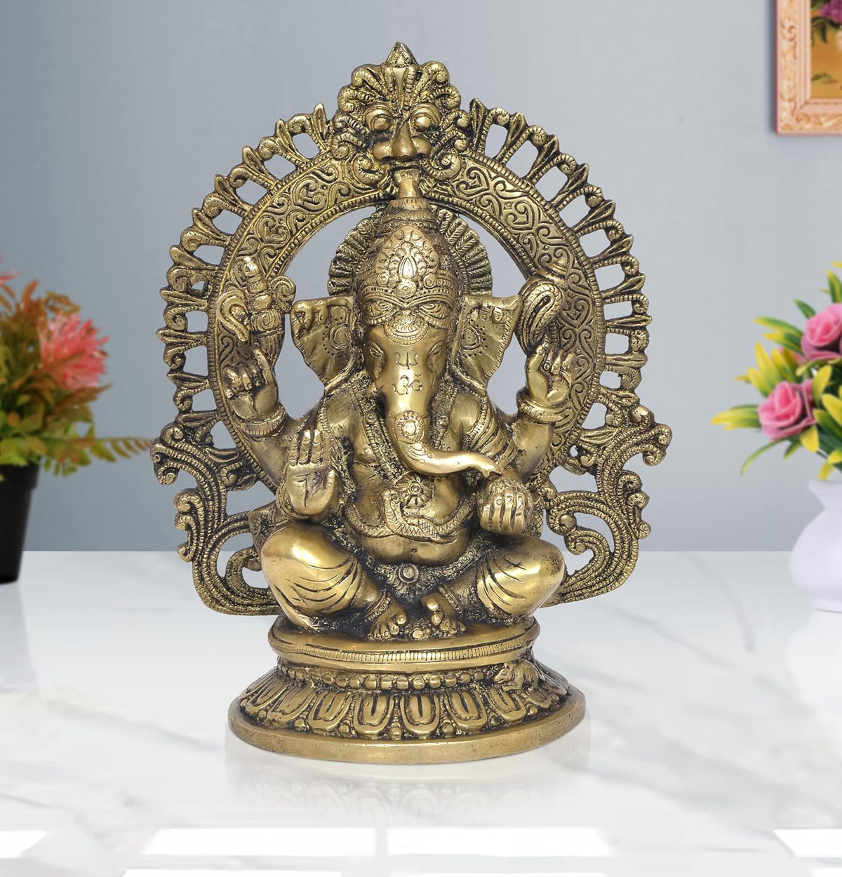 Brass Ganesha idol, seated with ornate halo and raised hands, highly detailed face