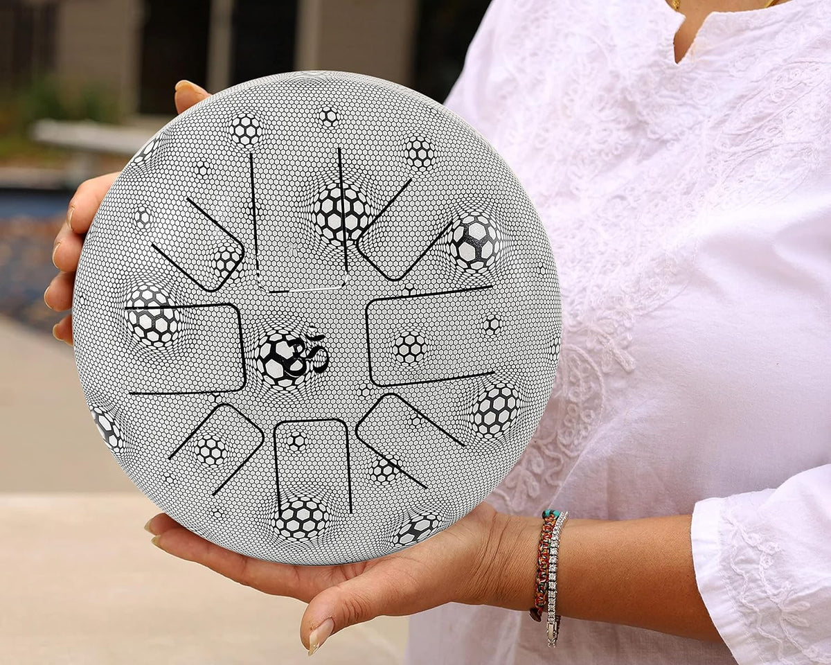 Happy steel drum with soccer pattern, black-silver finish, held in hand