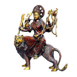 Brass Durga statue on lion with crown, red draped skirt and four arms holding tridents