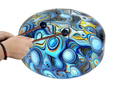 Hand pressing rubber mallets on blue peacock steel tongue drum with black striker tips