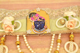 Green-gold toran band with Radha Krishna medallion, ivory roses, and hanging pearls