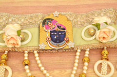 Green-gold toran band with Radha Krishna medallion, ivory roses, and hanging pearls