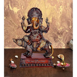 Brass Ganesha statue seated on mouse with raised hands, maroon base