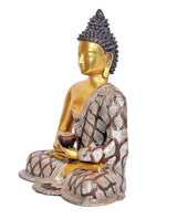 Brass Buddha meditation statue in profile, gold face and patterned robe, seated