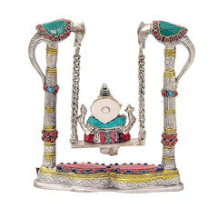 Front view of Lord Ganesha on brass swing jhula with colorful base, chains visible