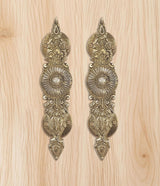 Golden brass door handle pair, two matching pointed shields with central rosette
