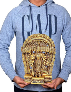 Golden brass Vishnu Dasavatara idol held in hands, on gray hoodie