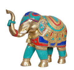 Brass elephant figurine close-up, raised trunk and teal-and-gold ornamented body