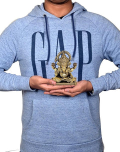 Brass Ganesha statue held in hands, seated idol with ornate crown