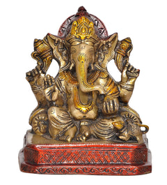 Lord Ganesha brass statue front view, golden face with crown, red patterned pedestal
