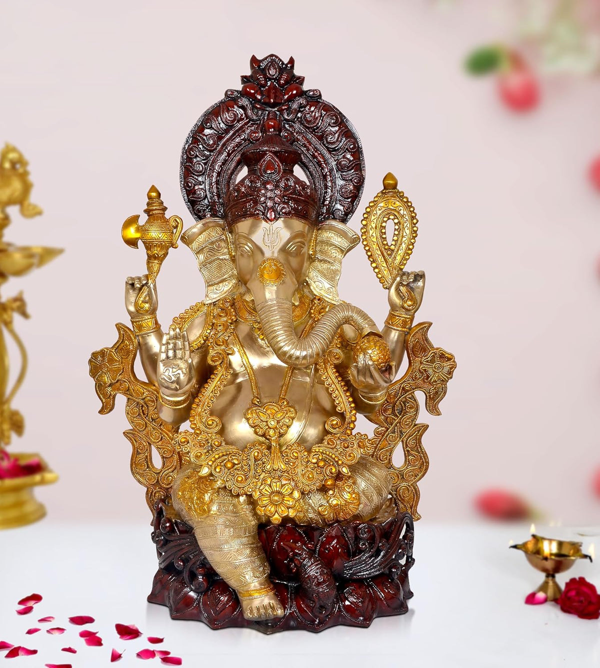 Gold and dark red Ganesha brass idol statue with four arms, seated on ornate base