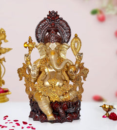Gold and dark red Ganesha brass idol statue with four arms, seated on ornate base