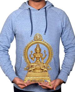 Brass Lakshmi statue held by person, seated goddess with prabhavali arch