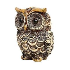 Owl showpiece statue in white with gold-brown speckled eyes and scalloped feathers.