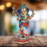 Dancing Ganesha brass idol with multicolor jeweled attire and raised arms, round base