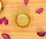 Close-up gold metal lotus diya oil lamp with embossed petal details