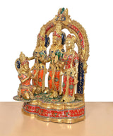 Side view of Ram Darbar brass idol with arched halo and colorful painted garments