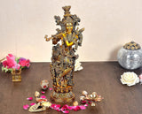 Brass Lord Krishna idol with ornate crown, flute, and standing pose on pedestal