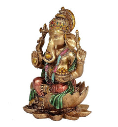 Ganesha idol angled view with green and pink drape, gold trunk, lotus base