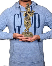 Brass Lord Krishna flute idol figurine on pedestal, held in hands for display