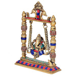 Side view of brass Ganesha on swing with blue-and-red striped base and chains