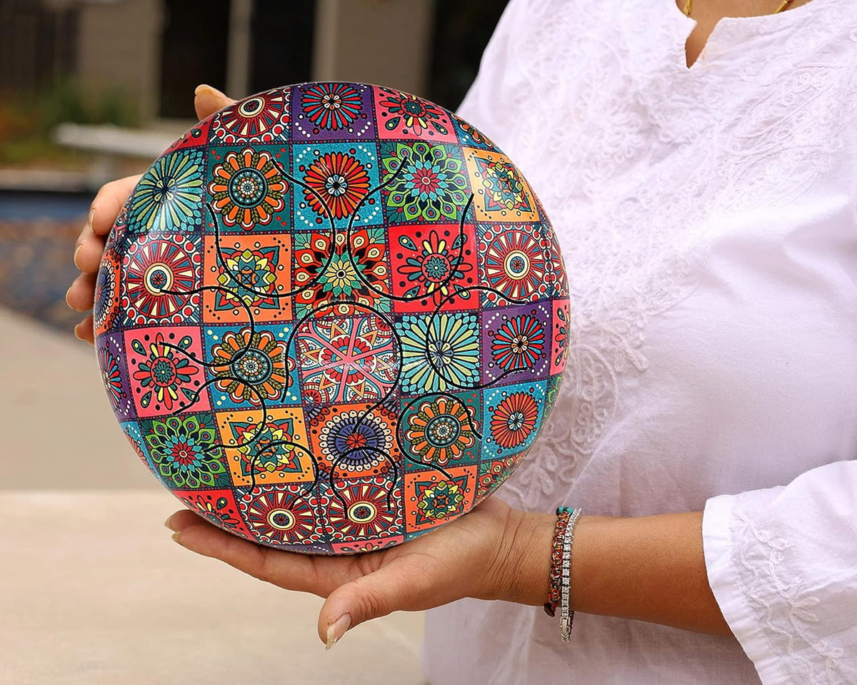 Colorful happy steel drum with patchwork mandala pattern, held in hands