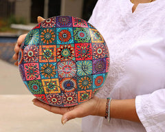 Colorful happy steel drum with patchwork mandala pattern, held in hands