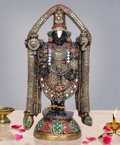 Multicolored brass idol statue with arched arms, ornate crown and jeweled garments