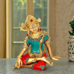 Indra brass idol, seated pose with teal torso and red gem-studded accents, gold face