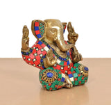 Brass Ganesha sculpture, gold-toned with multicolor skirt and blue circular accents