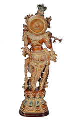 Back view of brass Krishna figurine, decorative halo, embossed details on the base