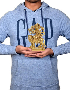Durga Maa brass statue on pedestal held in hands with blue hoodie, 5 inch