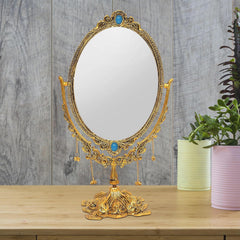 Gold-plated oval table mirror with intricate filigree, blue center jewels, dangling chains