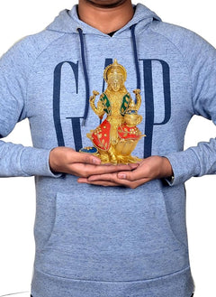 Lakshmi brass statue held over blue hoodie, seated on lotus with multicolor dress