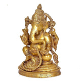 Brass Ganesha statue idol side view, detailed trunk, raised arms and ornaments