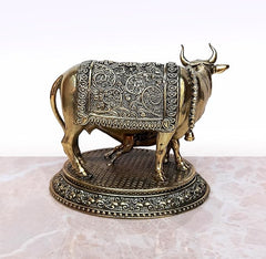 Brass cow and calf figurine, front view with decorative swirl pattern on saddle