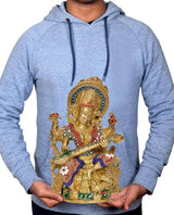 Hands holding brass Saraswati statue, seated goddess with flute and colorful jeweled dress
