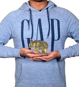 Brass elephant decor held in hands on light blue hoodie, 4 inch gift figurine