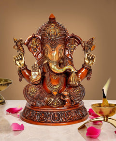 Brass Ganesha statue idol with seated figure and four raised arms, ornate gold detailing