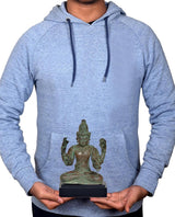Person holding vintage bronze Lord Vishnu statue on dark base, height about 7 inches