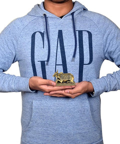 Brass Nandi cow idol on base held in hands, small decorative statue