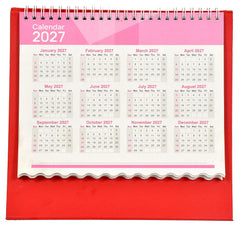 Table calendar 2027 open view with monthly date grids and spiral binding, red cover