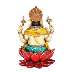 Resin Ganesha idol from behind, decorative crown and yellow drape on lotus base