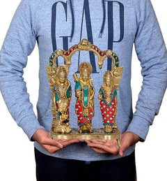 Ram Darbar brass idol held in hands, featuring three seated/standing figures