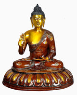 Brass seated Buddha idol, raised hand in blessing, brown robe with gold details