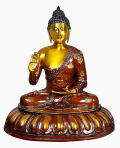 Brass seated Buddha idol, raised hand in blessing, brown robe with gold details